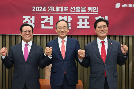 8일 여의도 국회에서 열린 국민의힘 원내대표 선출을 위한 정견발표회에 참석한 이종배(왼쪽부터), 추경호, 송석준 의원이 손을 맞잡고 포즈를 취하고 있다. <연합뉴스>